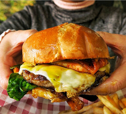 Person holding a burger from the Paperplane Cafe Sydney