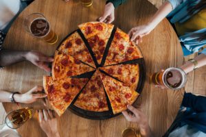 Top view group of young friends having pizza and beer. Best pizza in Melbourne list